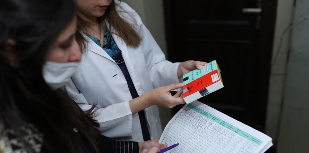 two researchers looking at an Investigational Medicinal Product ready to randomise a participant